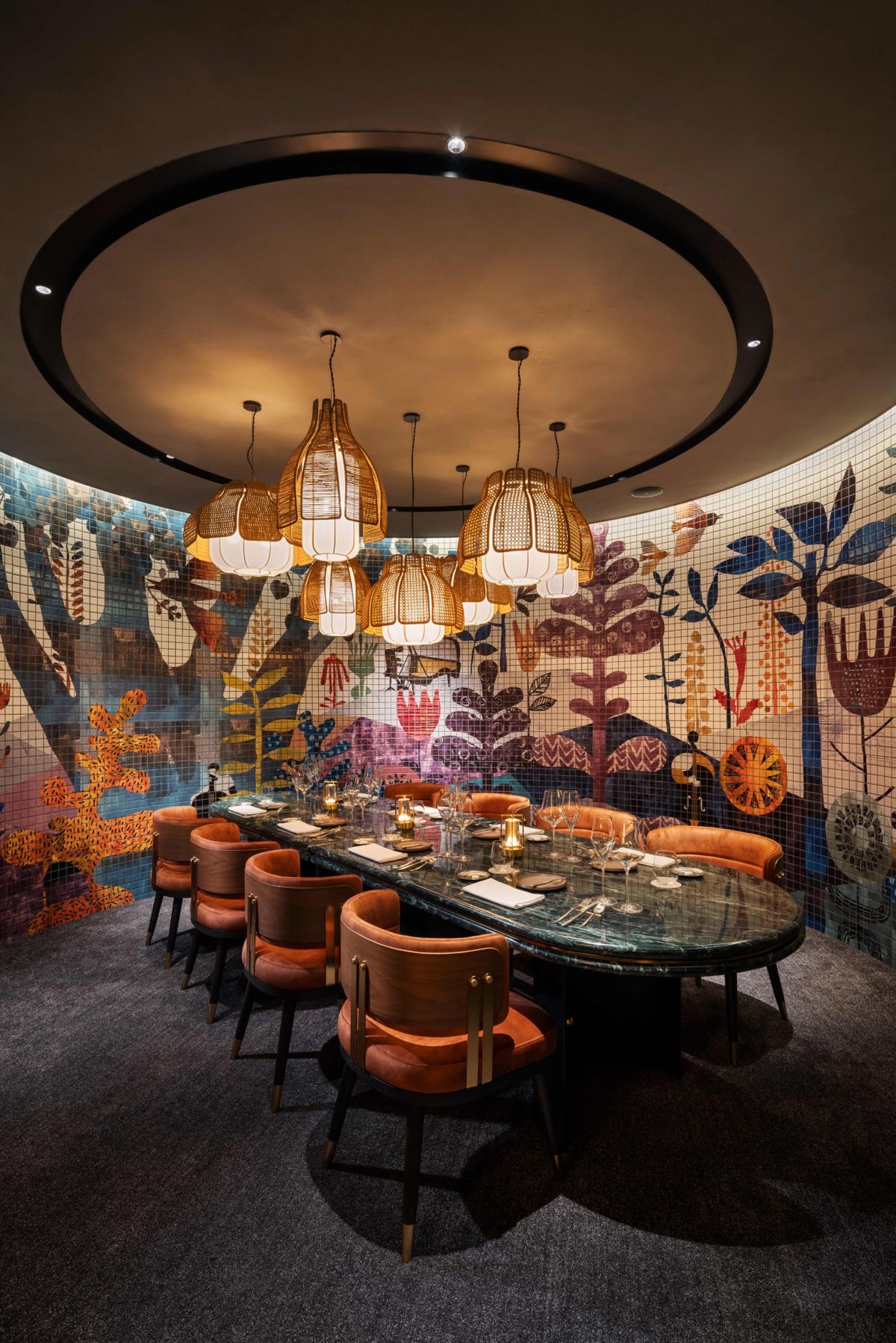 Intimate private dining room with a folk-art mural, rattan pendants and tan chairs